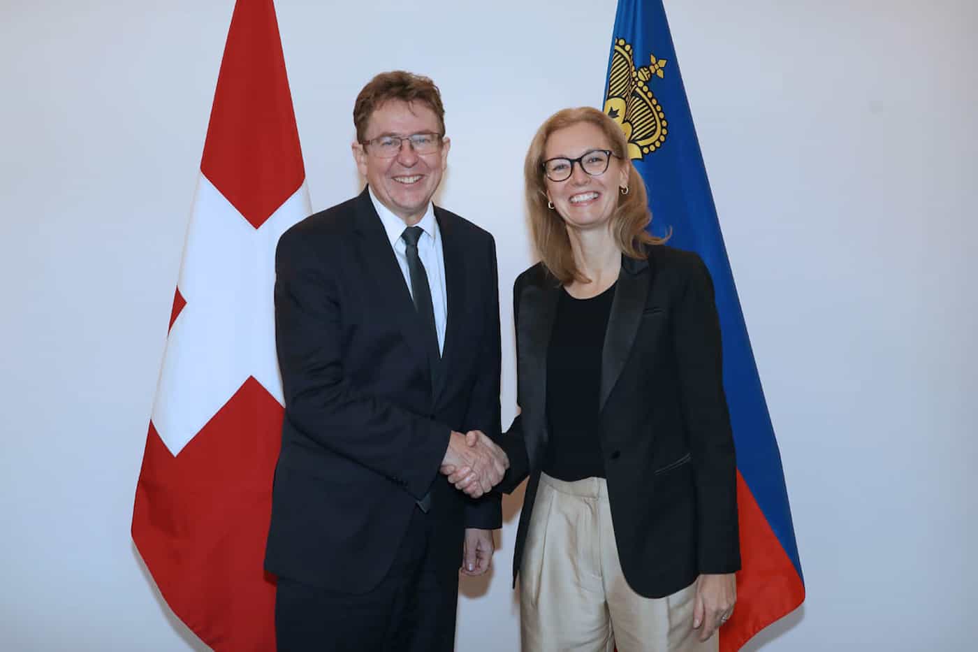 Bundesrat Albert Rösti wird von Regierungschef-Stellvertreterin Sabine Monauni im Regierungsgebäude begrüsst.