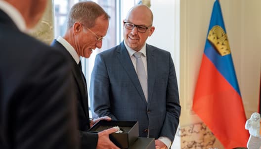 Staatsminister Axel Wintermeyer überreicht Regierungschef Daniel Risch ein Präsent